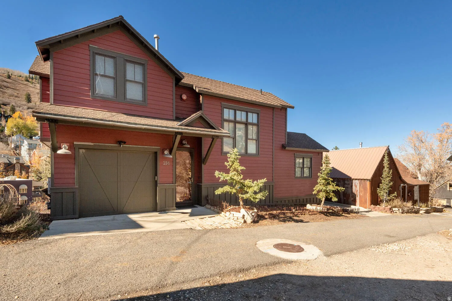 View of front facade with an attached garage, a shingled roof, and driveway