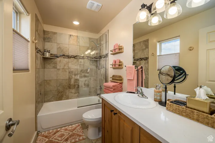 Full bathroom featuring shower / bath combination, vanity, and light tile patterned floors