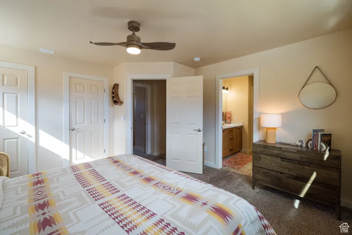 Bedroom featuring a ceiling fan, carpet floors, connected bathroom, and multiple closets