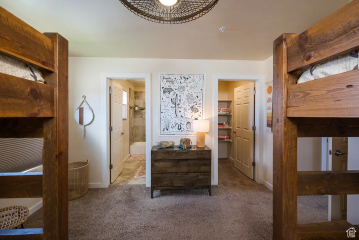 Carpeted bedroom with a spacious closet and connected bathroom