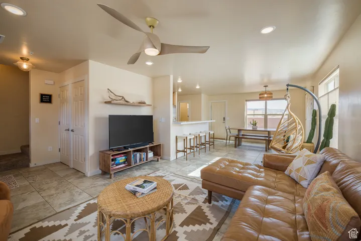 Tiled living room featuring stairway, recessed lighting, and a ceiling fan