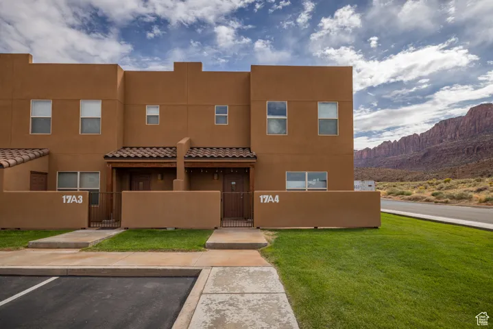 View of front of home featuring a gate, a fenced front yard, stucco siding, and uncovered parking