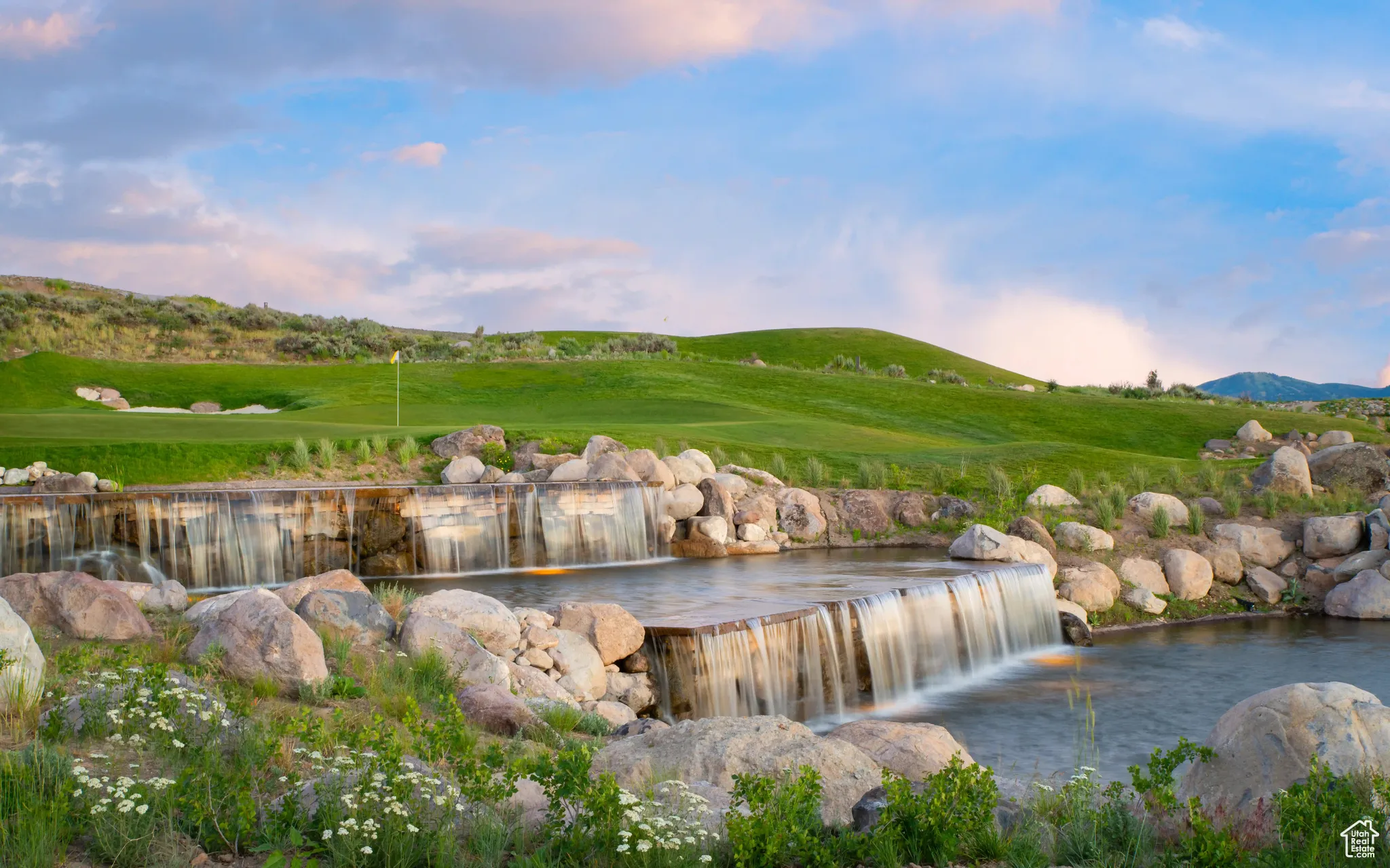Water view with a mountainous background and a golf course