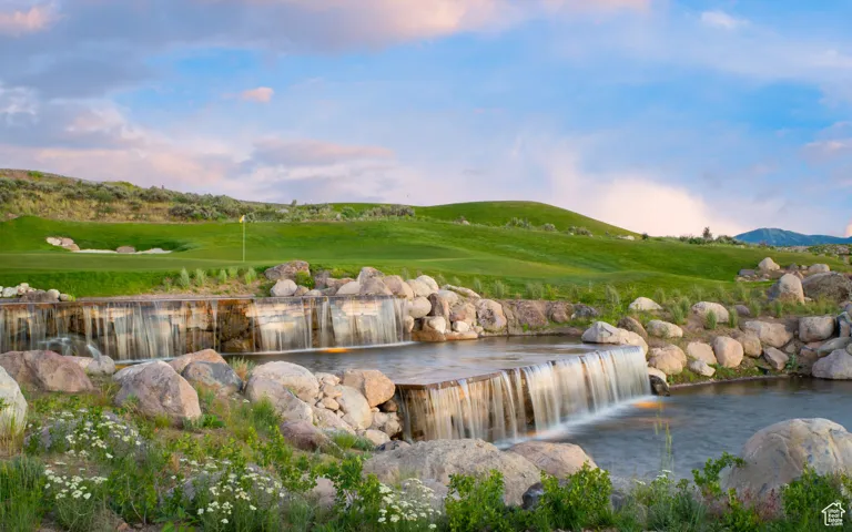 Water view with a mountainous background and a golf course