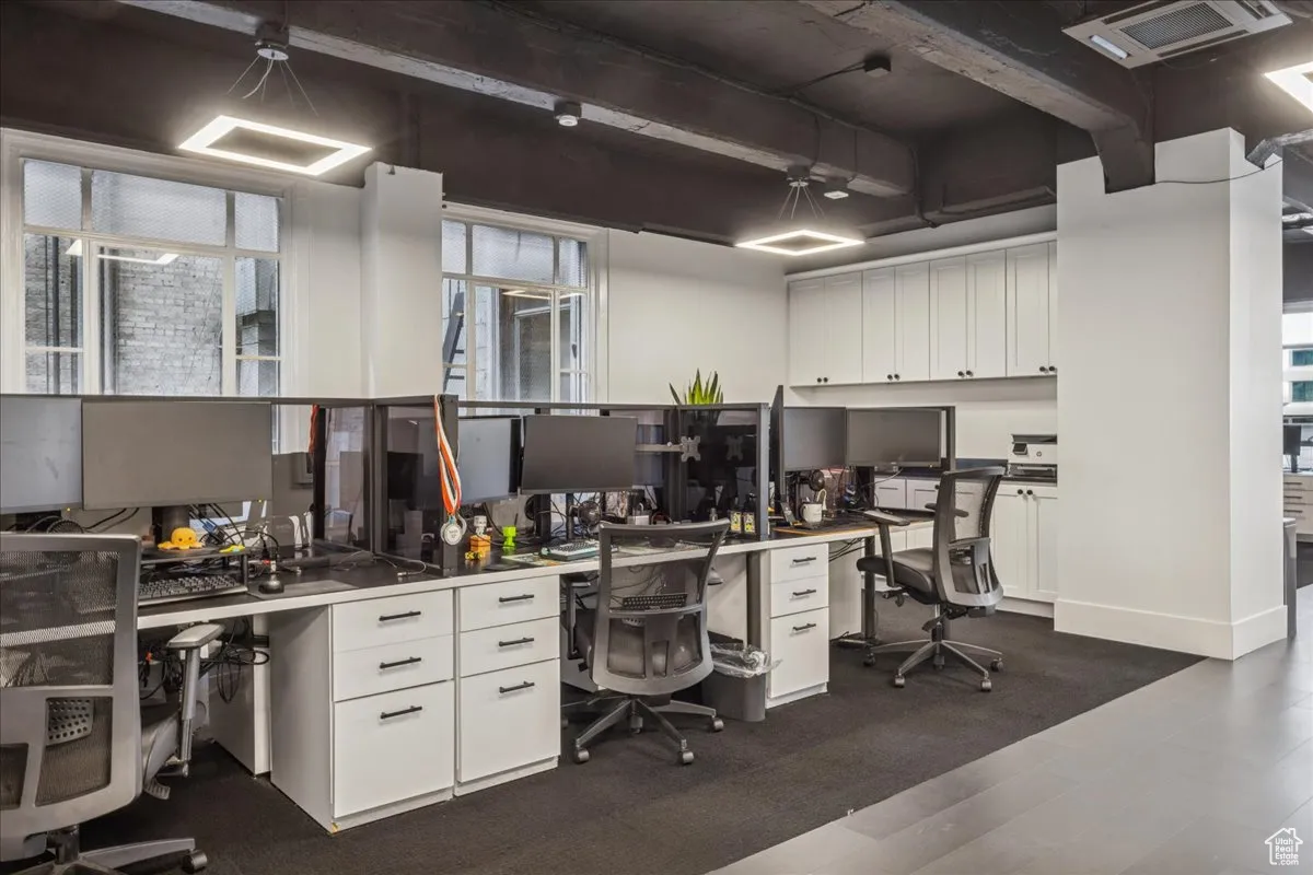 Office area featuring beam ceiling and built in copy or break area