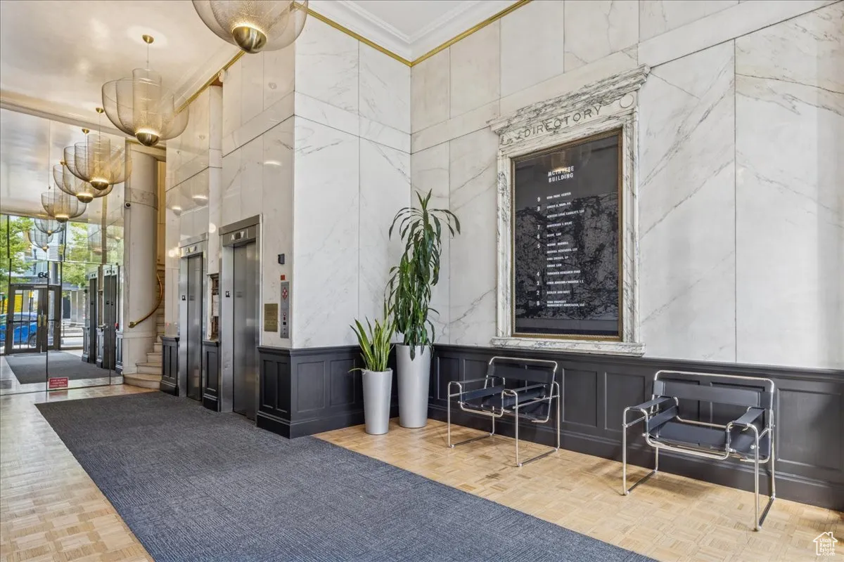 Common area with crown molding, a decorative wall, and stairway