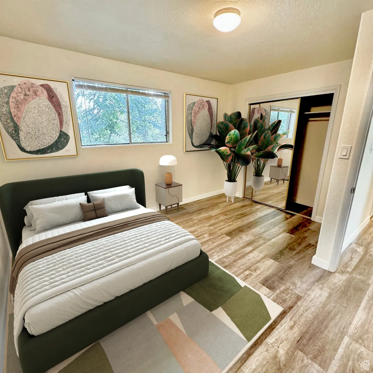 Bedroom featuring light wood finished floors, a textured ceiling, and a closet