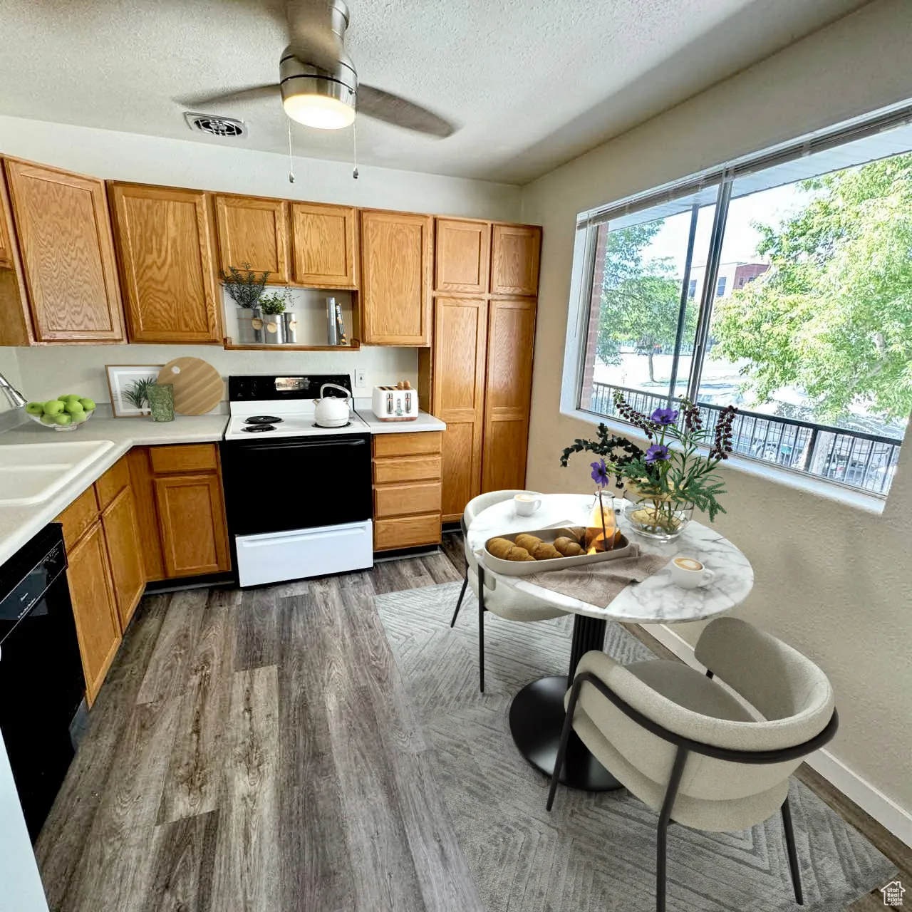 Kitchen with light countertops, electric range, brown cabinets, a textured ceiling, and black dishwasher