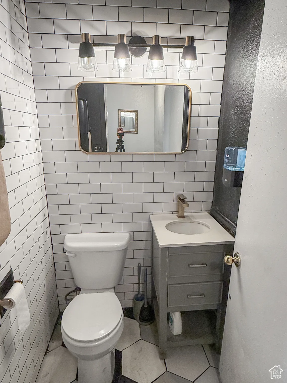 Half bath with vanity, tile walls, and tile patterned floors