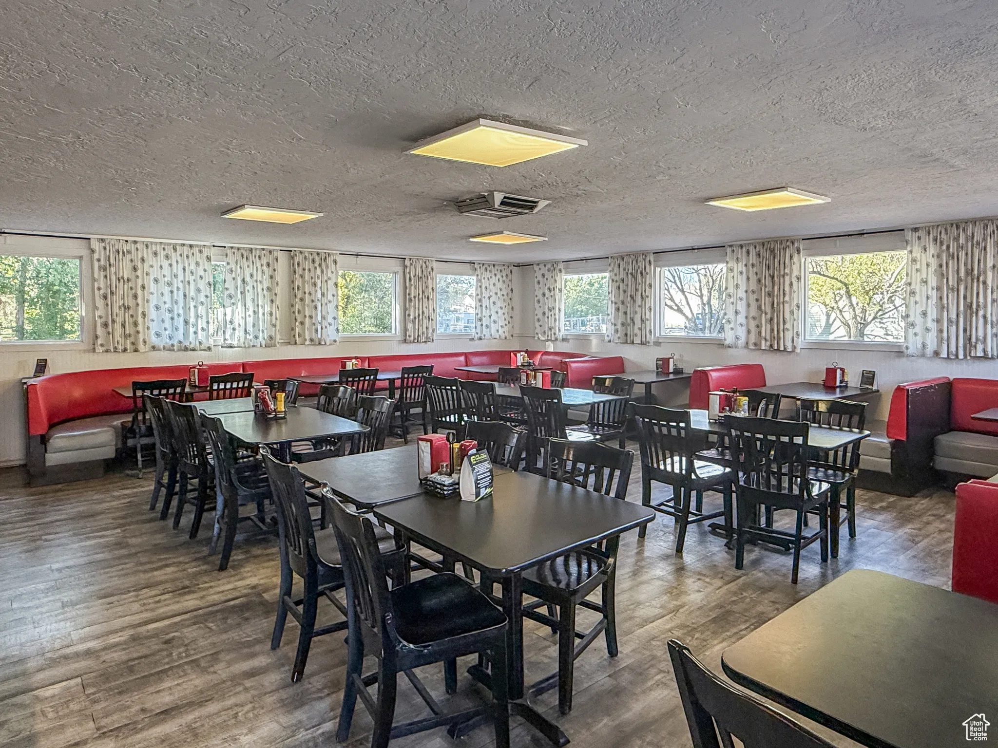 Dining space featuring plenty of natural light, wood finished floors, and a textured ceiling