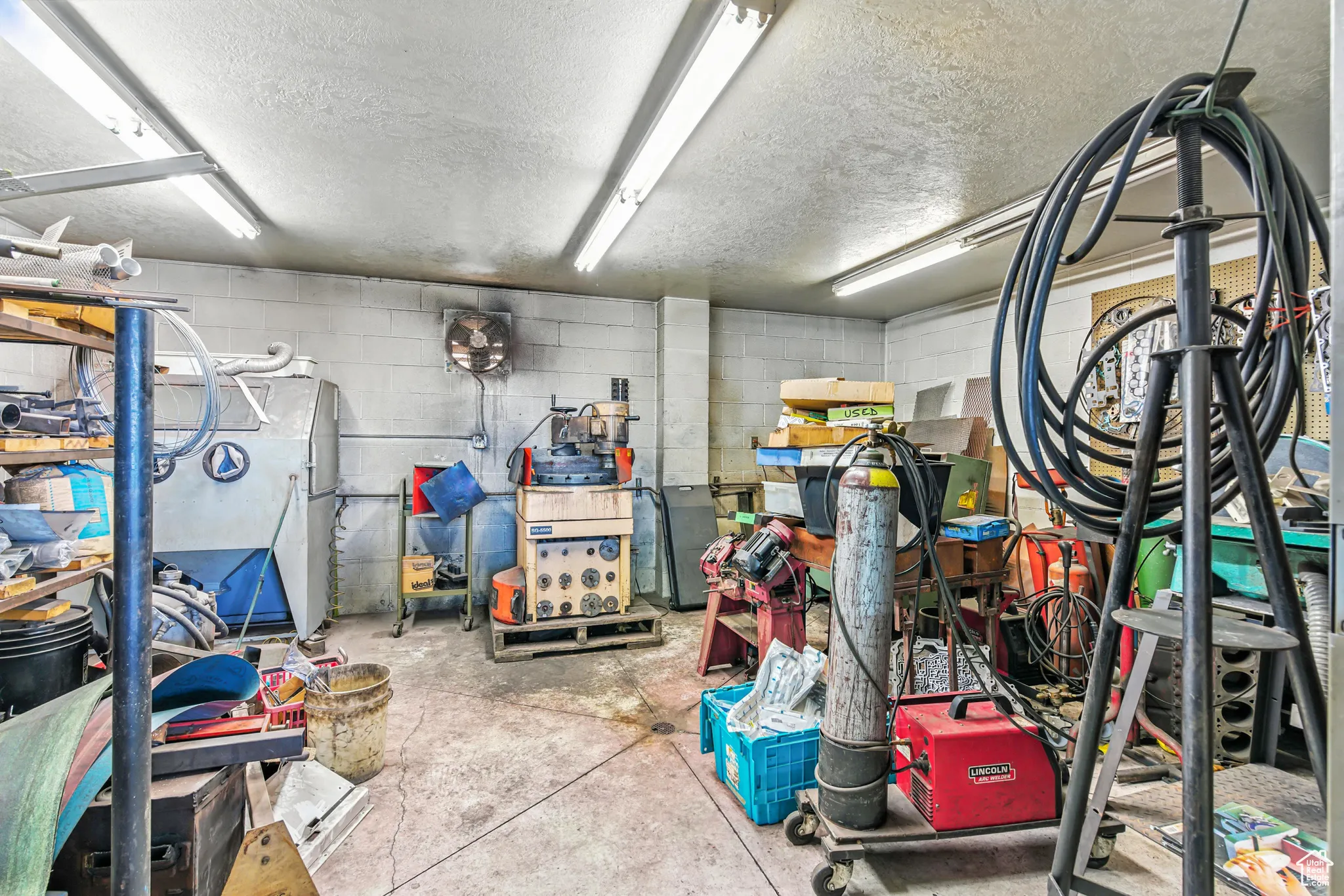 Garage featuring concrete block wall and refrigerator