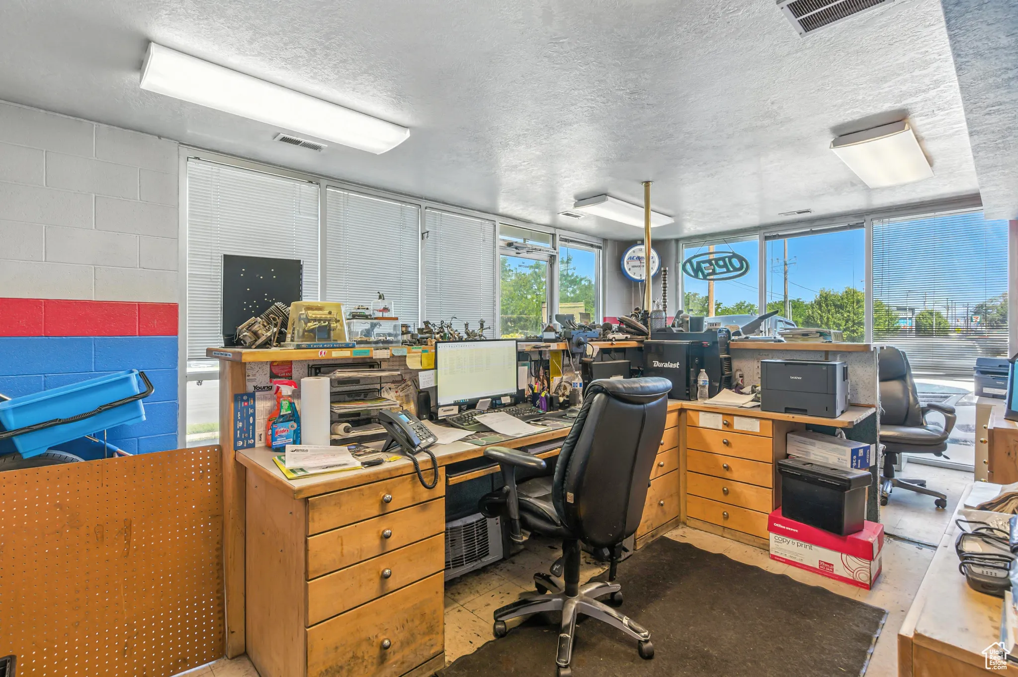 Home office with concrete block wall and a textured ceiling