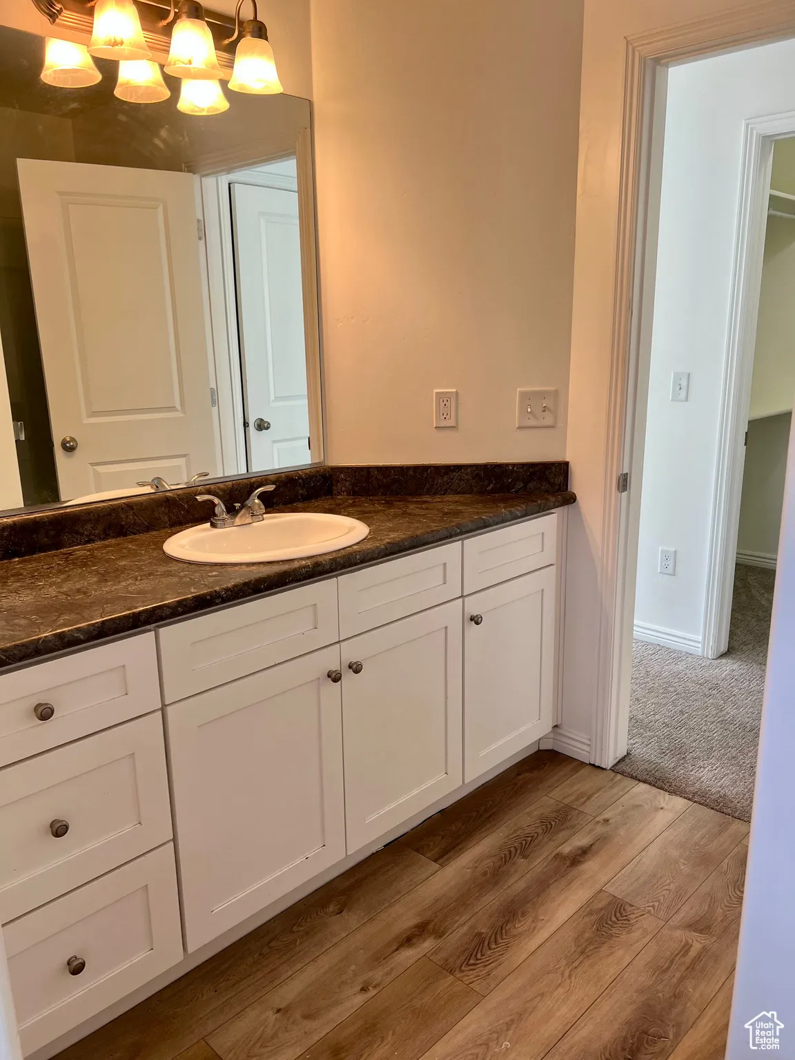 3/4 upstairs bathroom featuring vanity and light wood-style flooring.