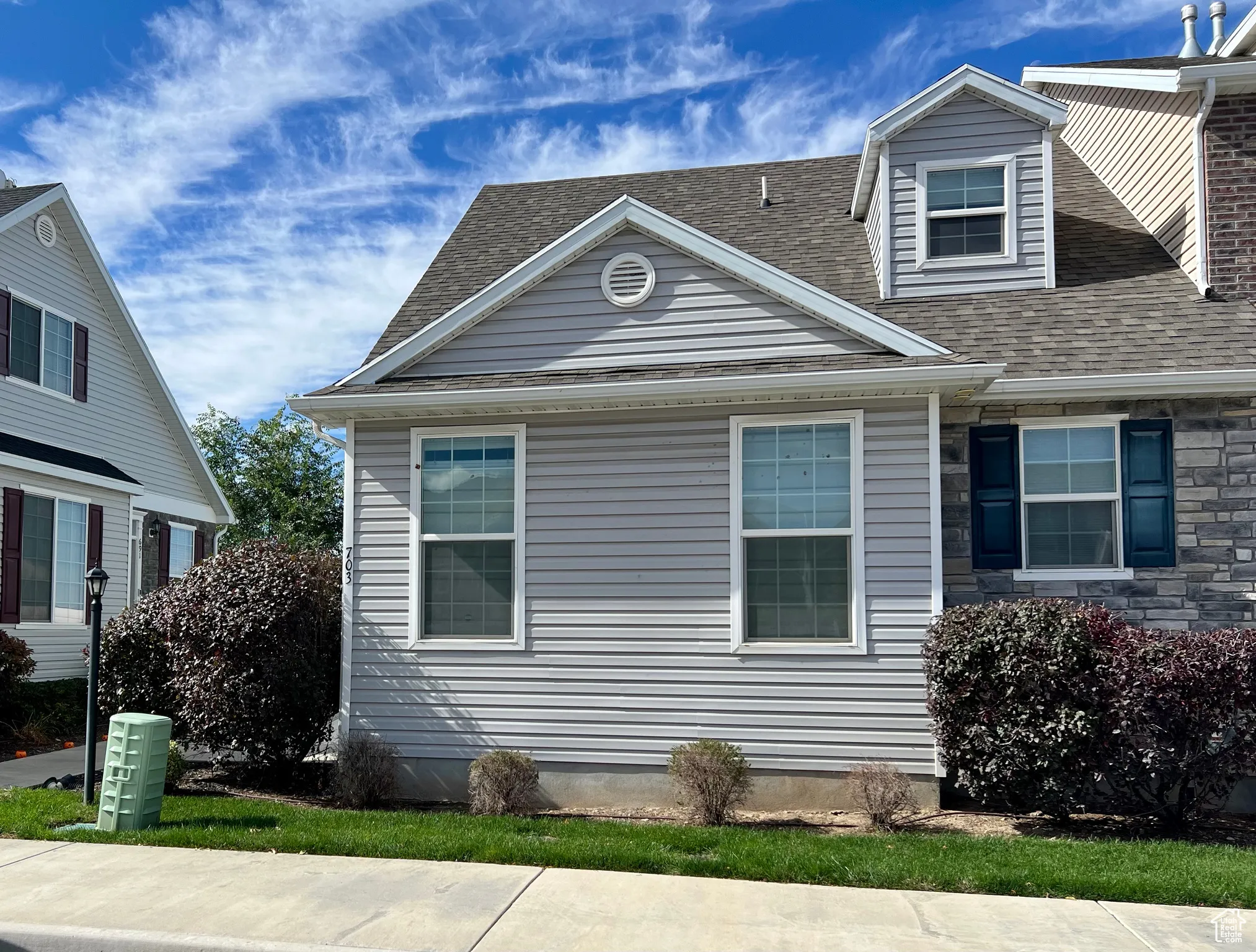 View of property exterior featuring a shingled roof and stone siding
