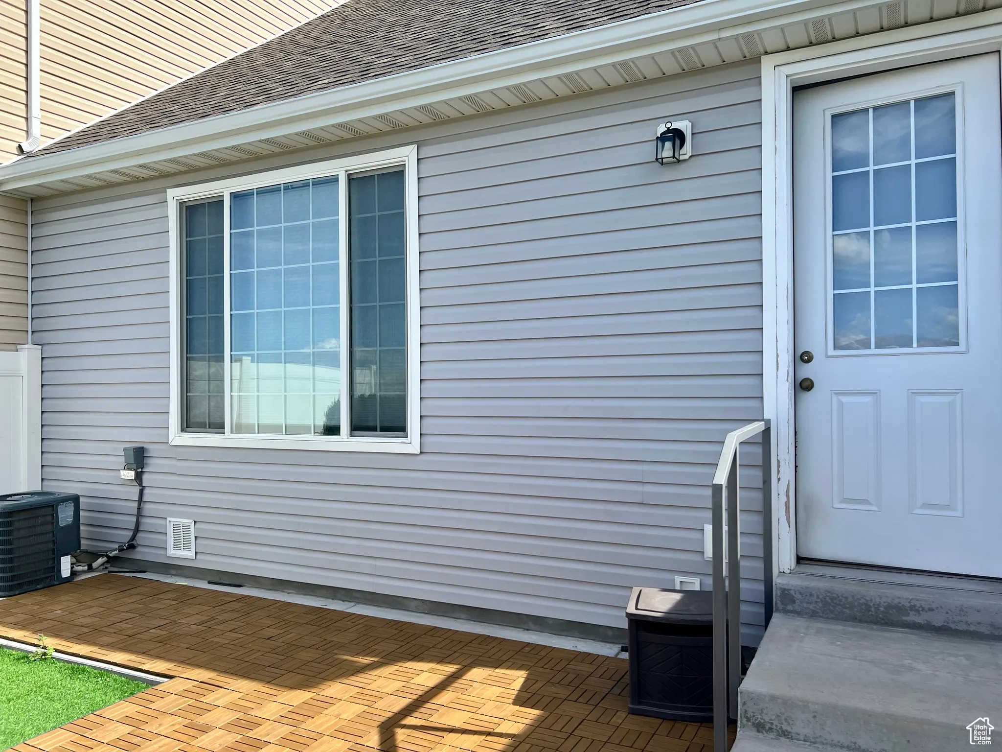 View of back of property with a shingled roof and a patio area