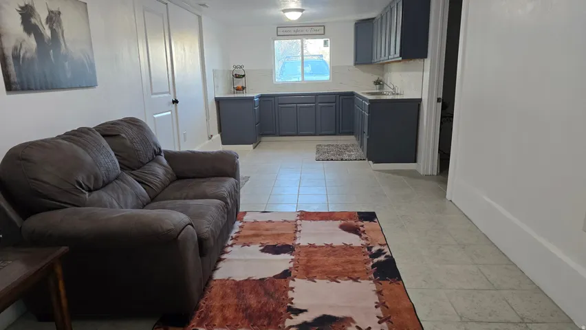 Open concept living area with light-toned tile flooring throughout