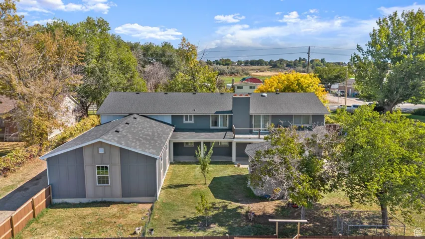 Aerial view of property and surrounding area featuring a tree filled landscape