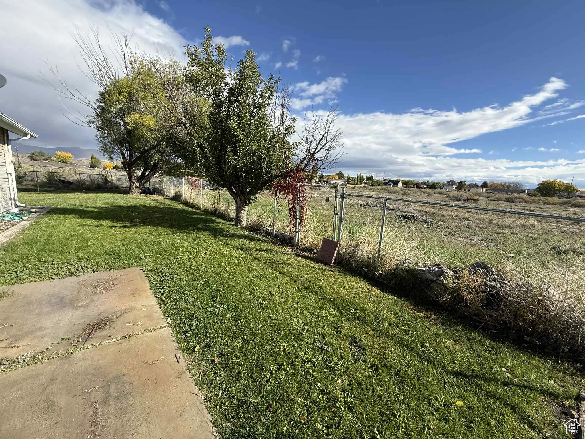 Fenced backyard with a view of countryside