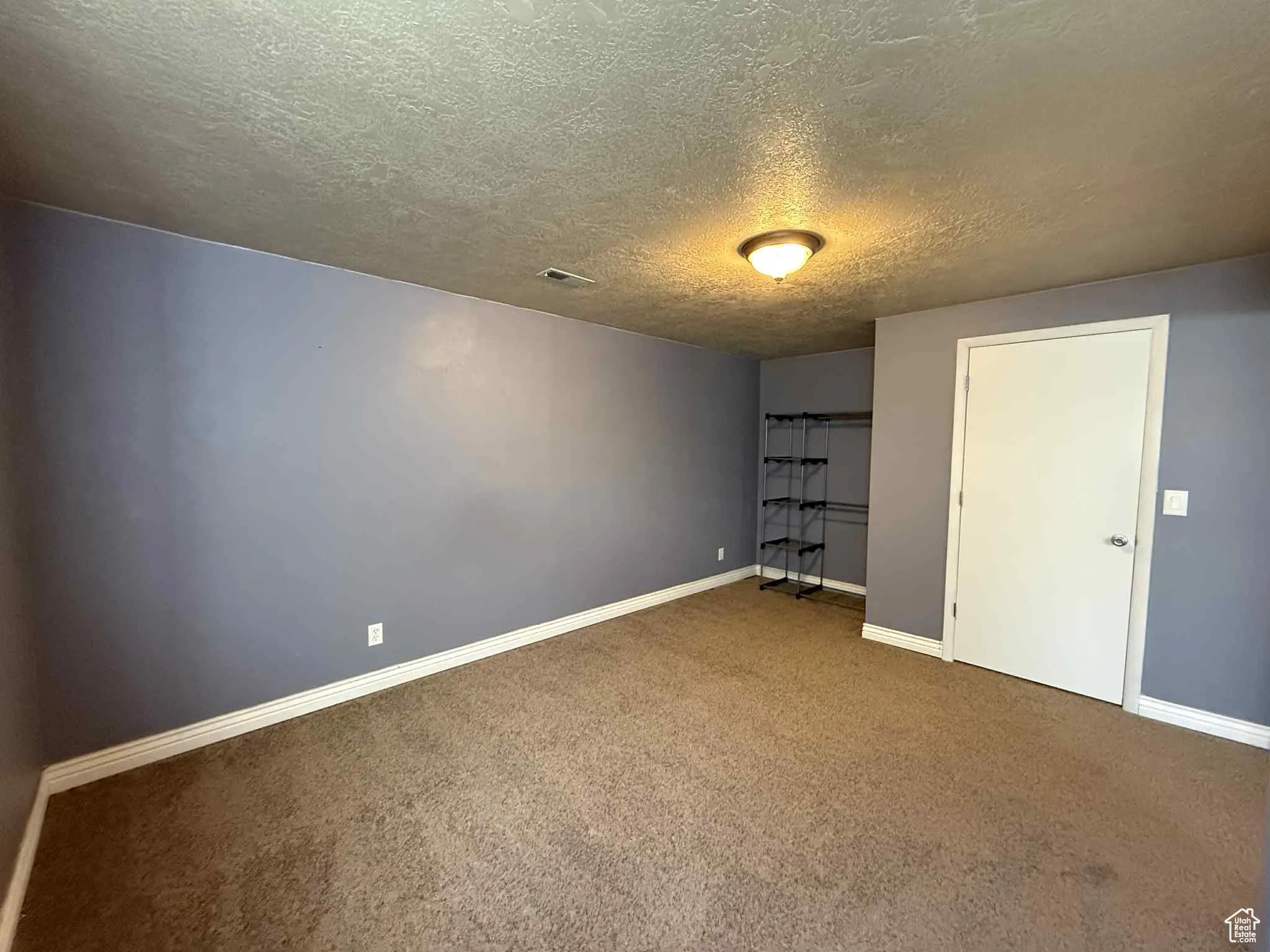 Optional 4th bedroom with a textured ceiling, carpet, and a closet