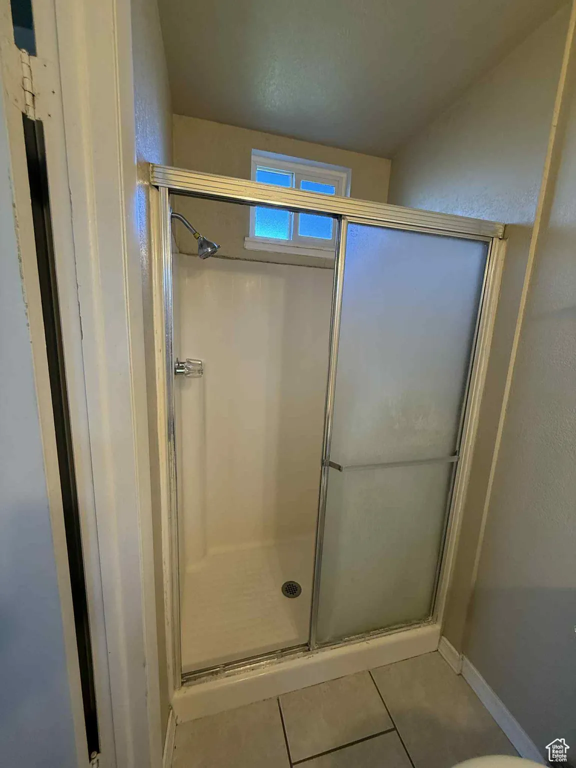 Master Bathroom featuring light tile patterned floors and a shower stall