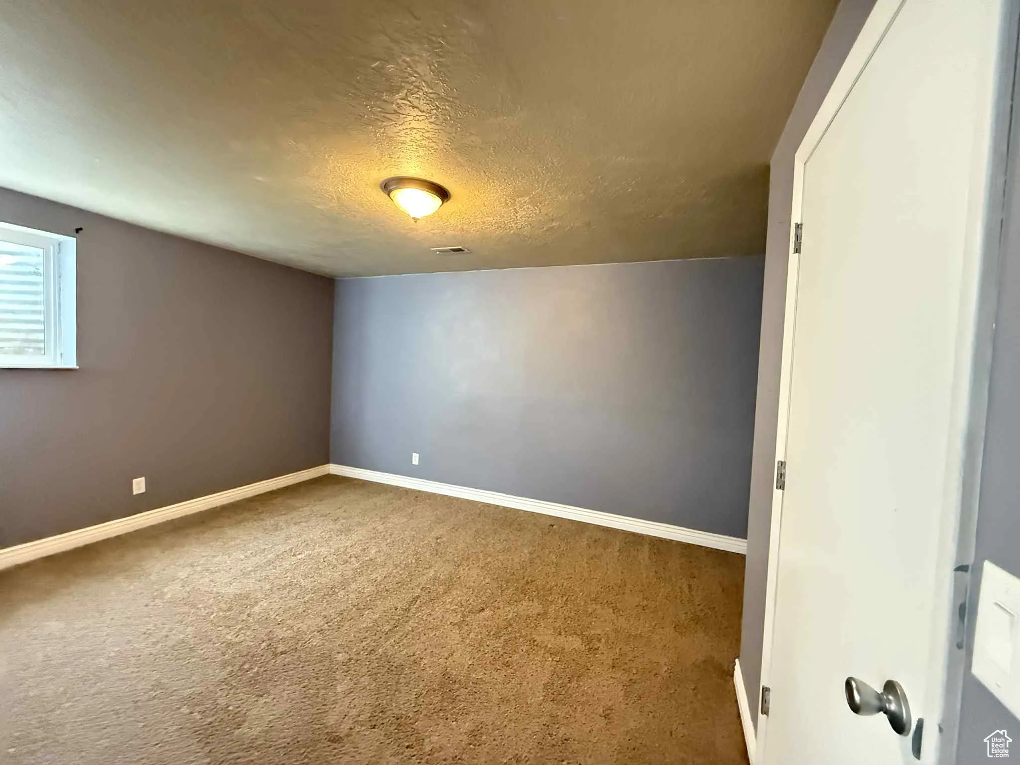 Optional 4th bedroom with a textured ceiling and light carpet