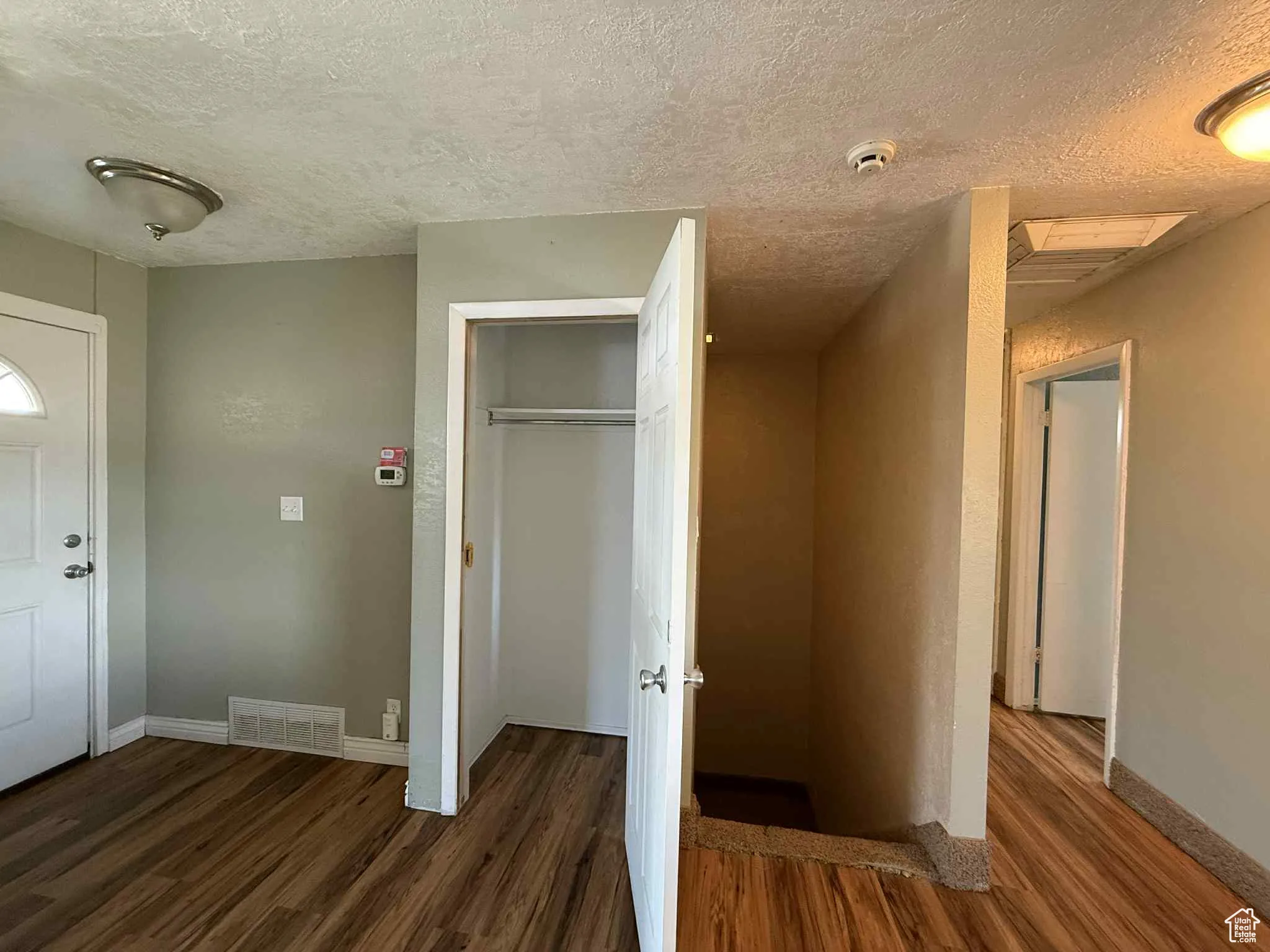 Foyer entrance with coat closet, stairs to basement and hallway
