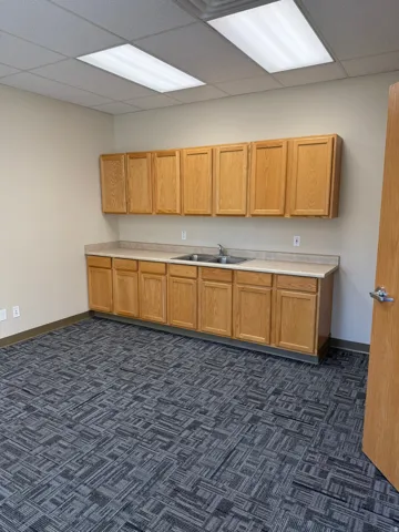 Kitchen featuring light countertops, dark carpet, and a drop ceiling