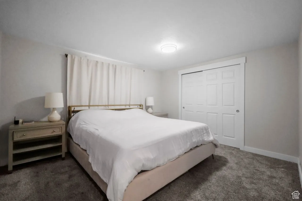 Carpeted bedroom with a closet and baseboards