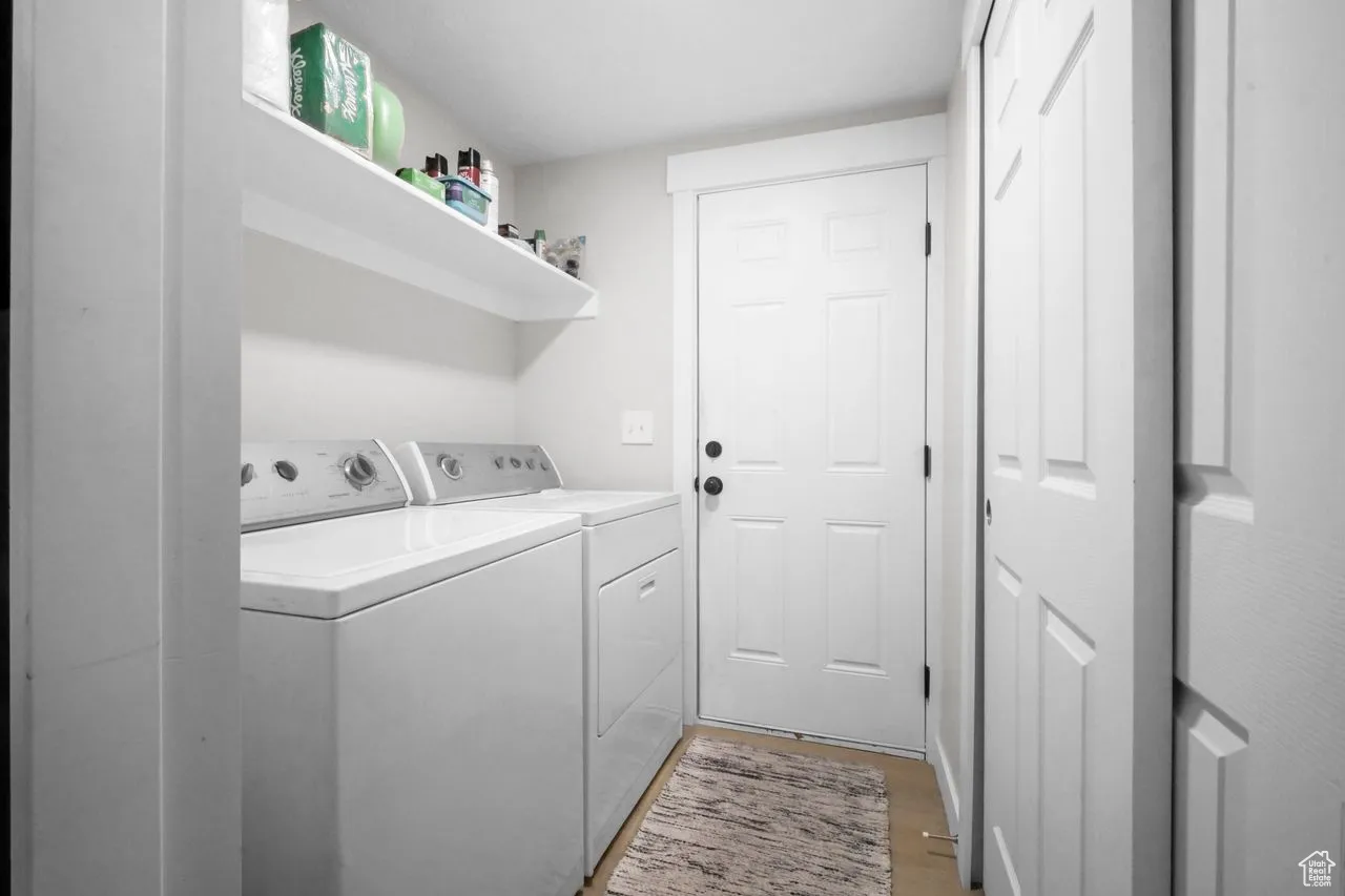 Laundry area featuring washer and clothes dryer and light wood-style flooring