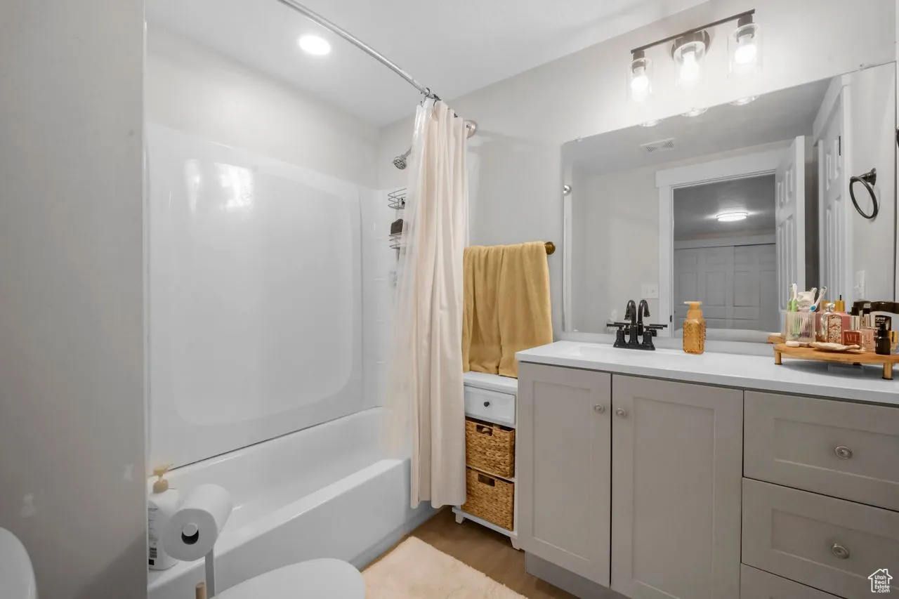 Bathroom with shower / bathtub combination with curtain and vanity