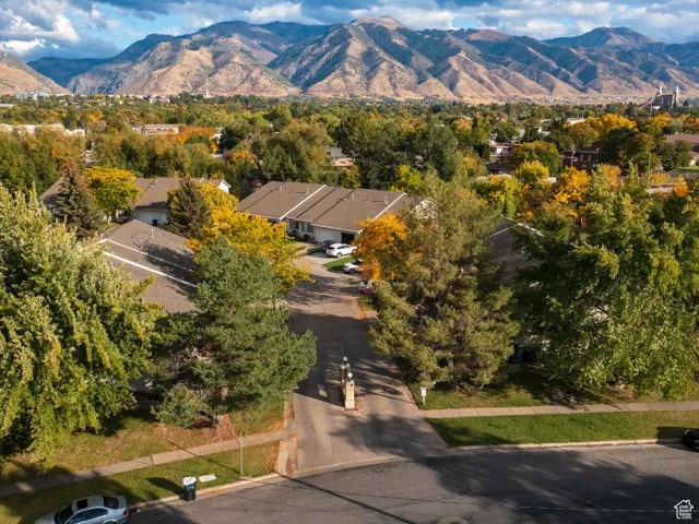 Aerial view of residential area with a mountain backdrop and a tree filled landscape