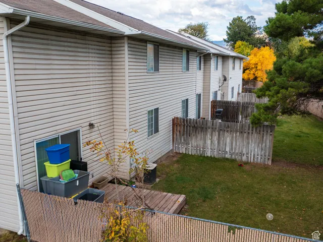 Back of property with roof with shingles and a wooden deck
