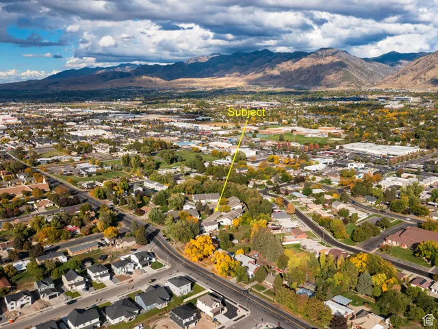 Aerial view of property's location with a mountainous background and nearby suburban area