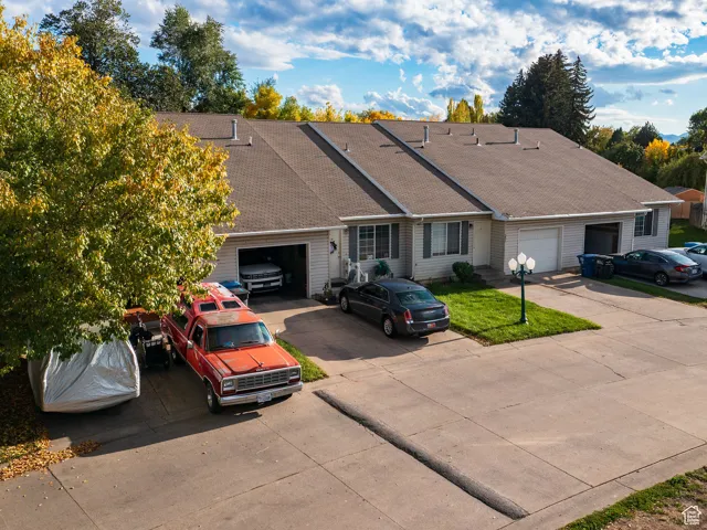 Single story home featuring roof with shingles, driveway, and an attached garage