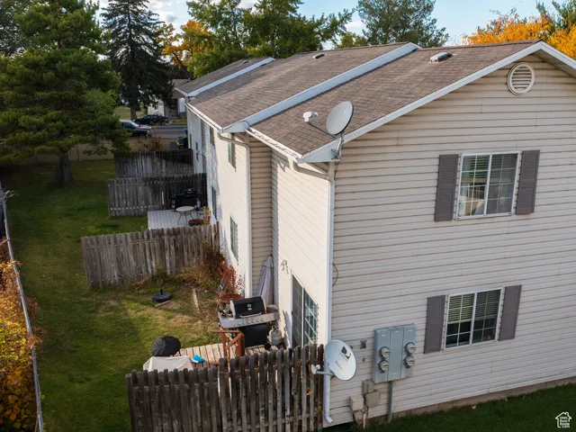 View of side of property with a shingled roof