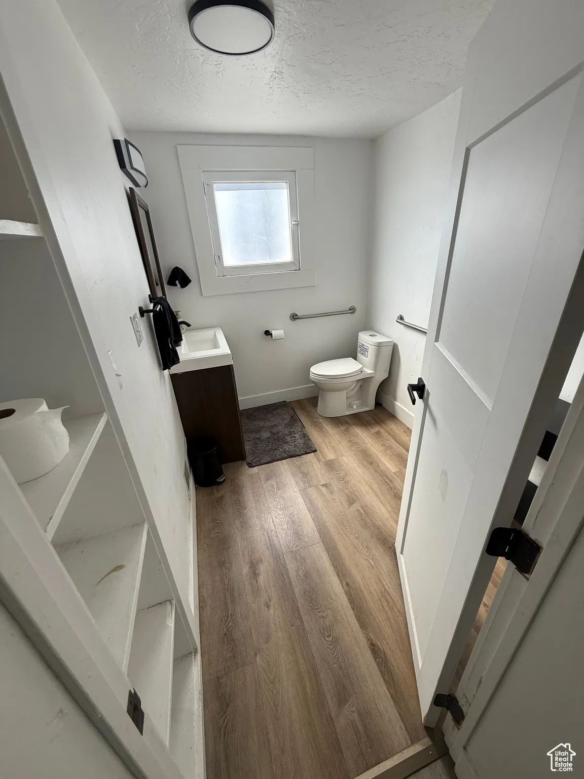 Bathroom featuring vanity, light wood finished floors, and a textured ceiling