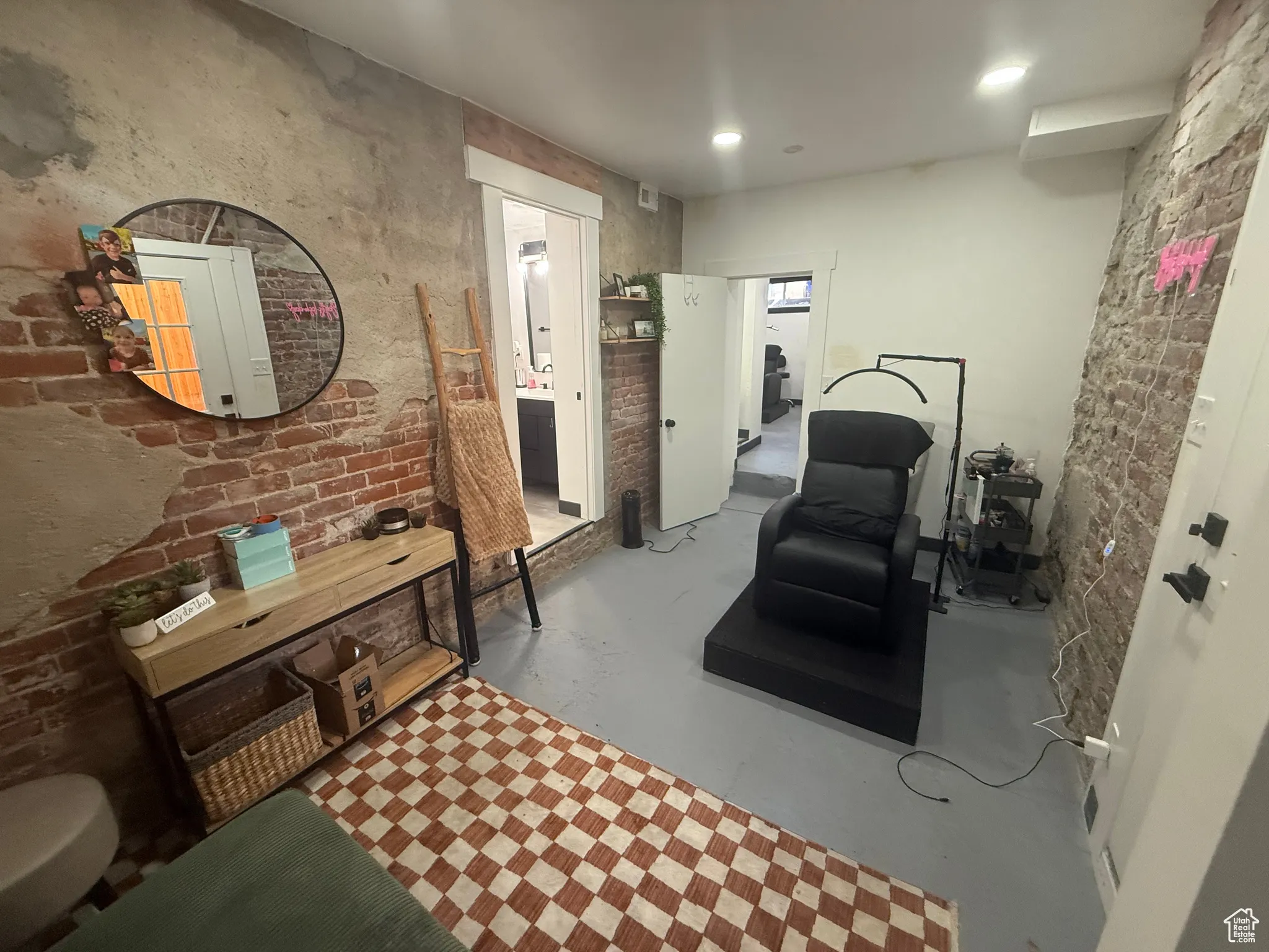 Basement Unit  featuring brick wall, finished concrete flooring, and ensuite bath