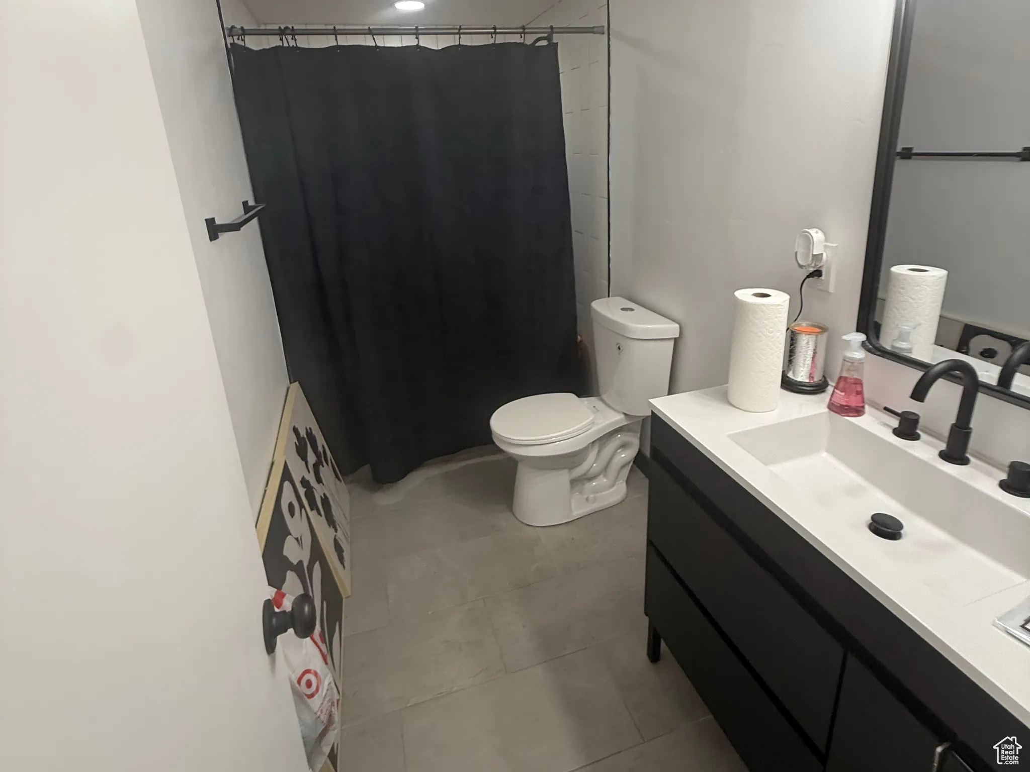 Bathroom with a textured ceiling, vanity, curtained shower, and light tile patterned floors