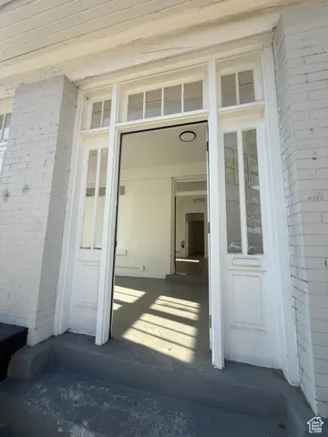 View of exterior entry featuring brick siding