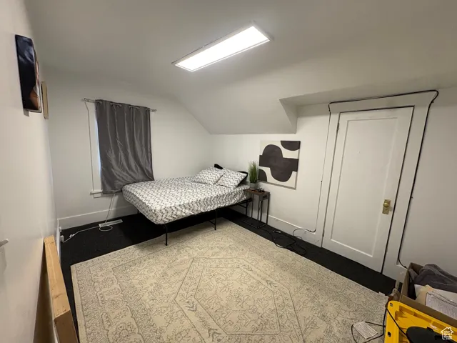 Bedroom featuring vaulted ceiling and baseboards