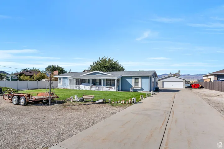 Single story home featuring a detached garage and an outbuilding