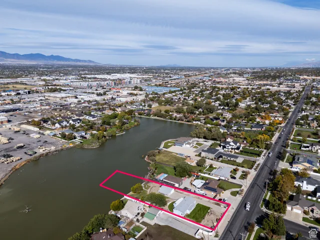 Aerial perspective of suburban area featuring property boundaries highlighted and a water and mountain view