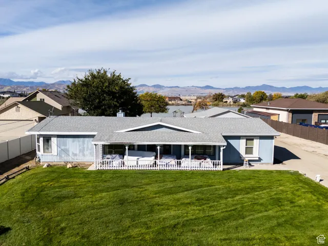 View of front of home featuring a shingled roof, a mountain view, a residential view, and a chimney