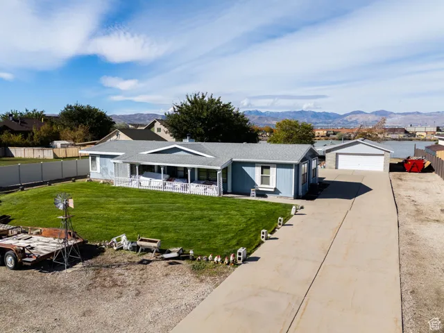 Single story home featuring a garage, driveway, a mountain view, and roof with shingles