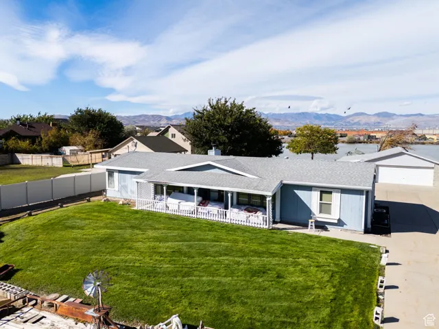 View of front of house featuring a shingled roof, driveway, a garage, and a mountain view