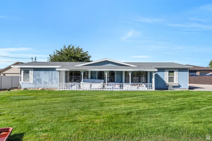 Ranch-style house featuring a shingled roof and a porch