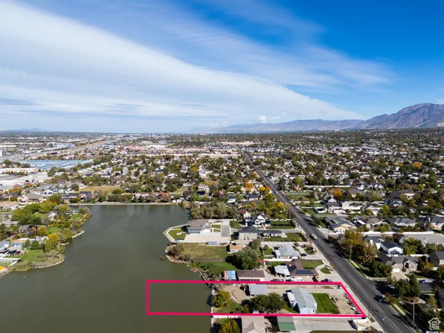 Aerial perspective of suburban area featuring property boundaries highlighted and a water and mountain view
