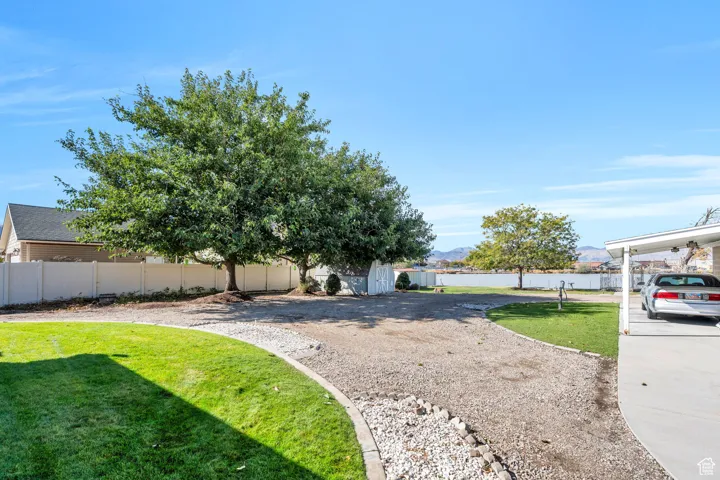 Fenced backyard with a storage unit and a mountain view