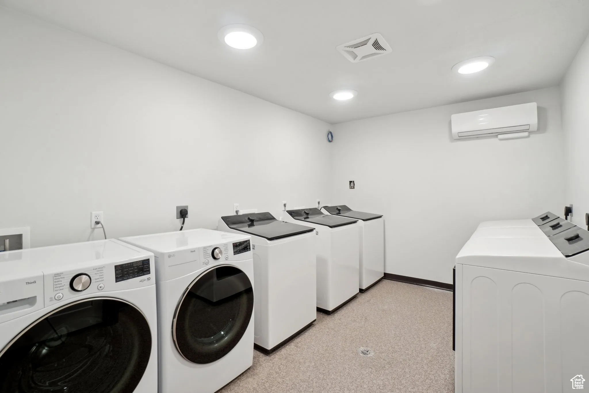 Laundry area featuring washer and clothes dryer, a wall mounted air conditioner, and recessed lighting