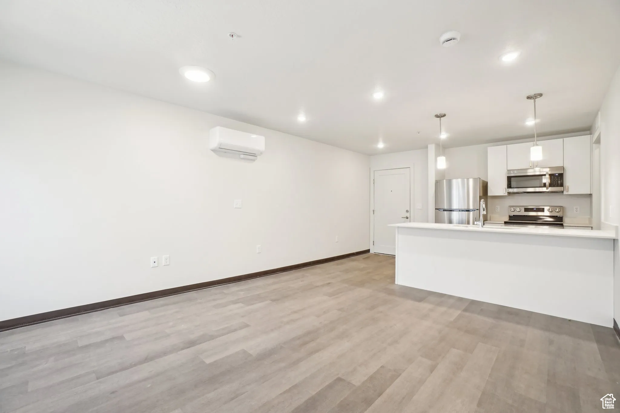 Unfurnished living room featuring light wood finished floors and recessed lighting